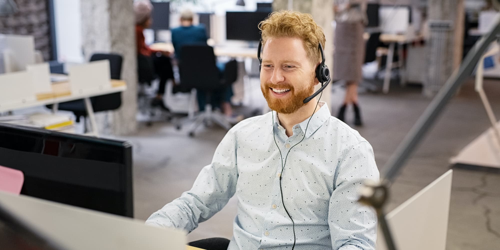 person sitting at desk in office with phone headset on