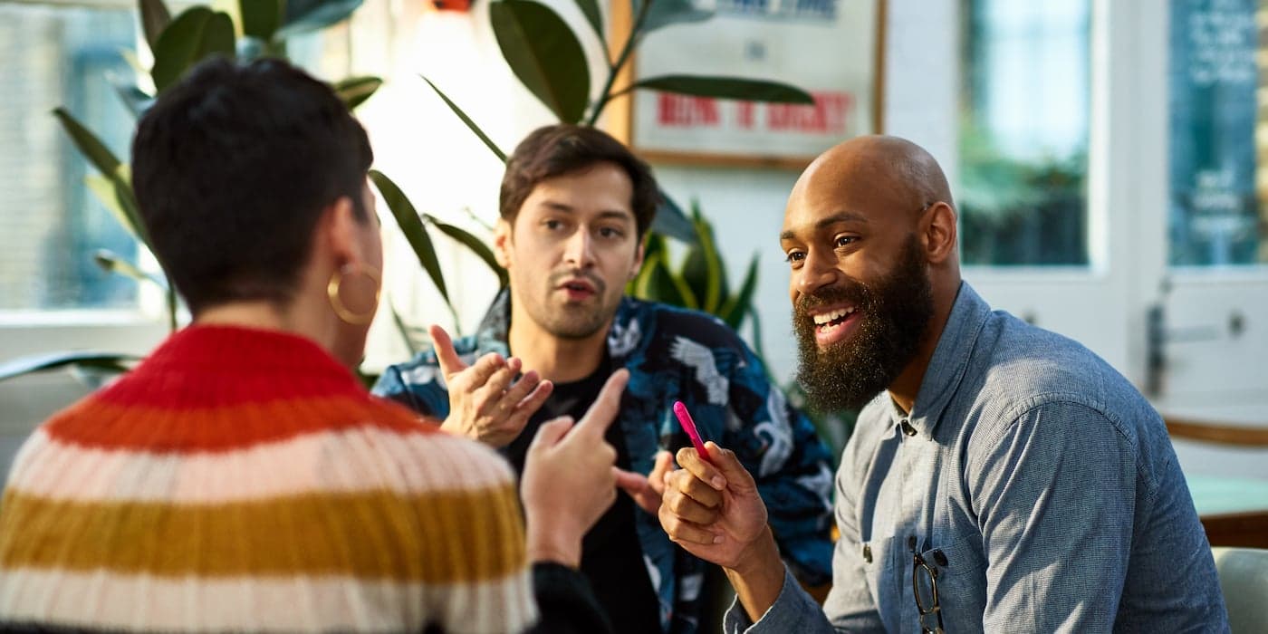group of three coworkers talking in an office