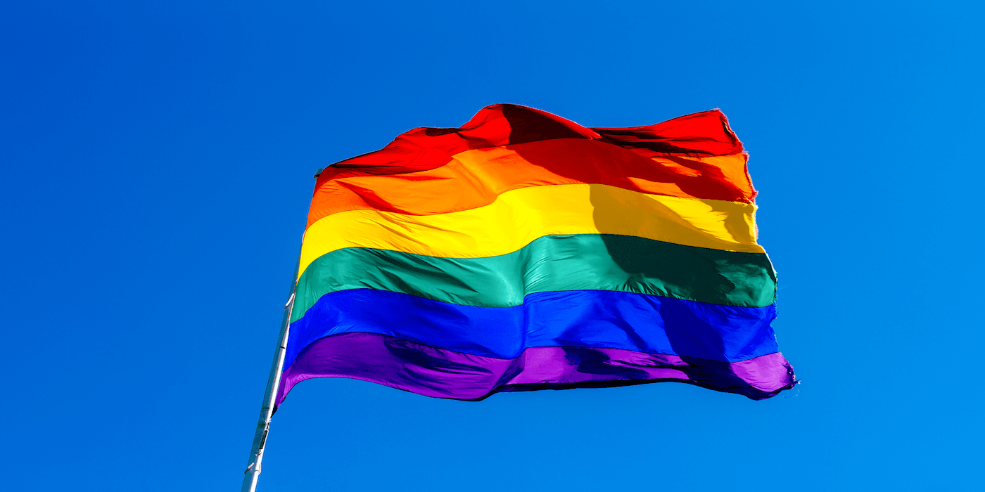Rainbow flag against a blue sky