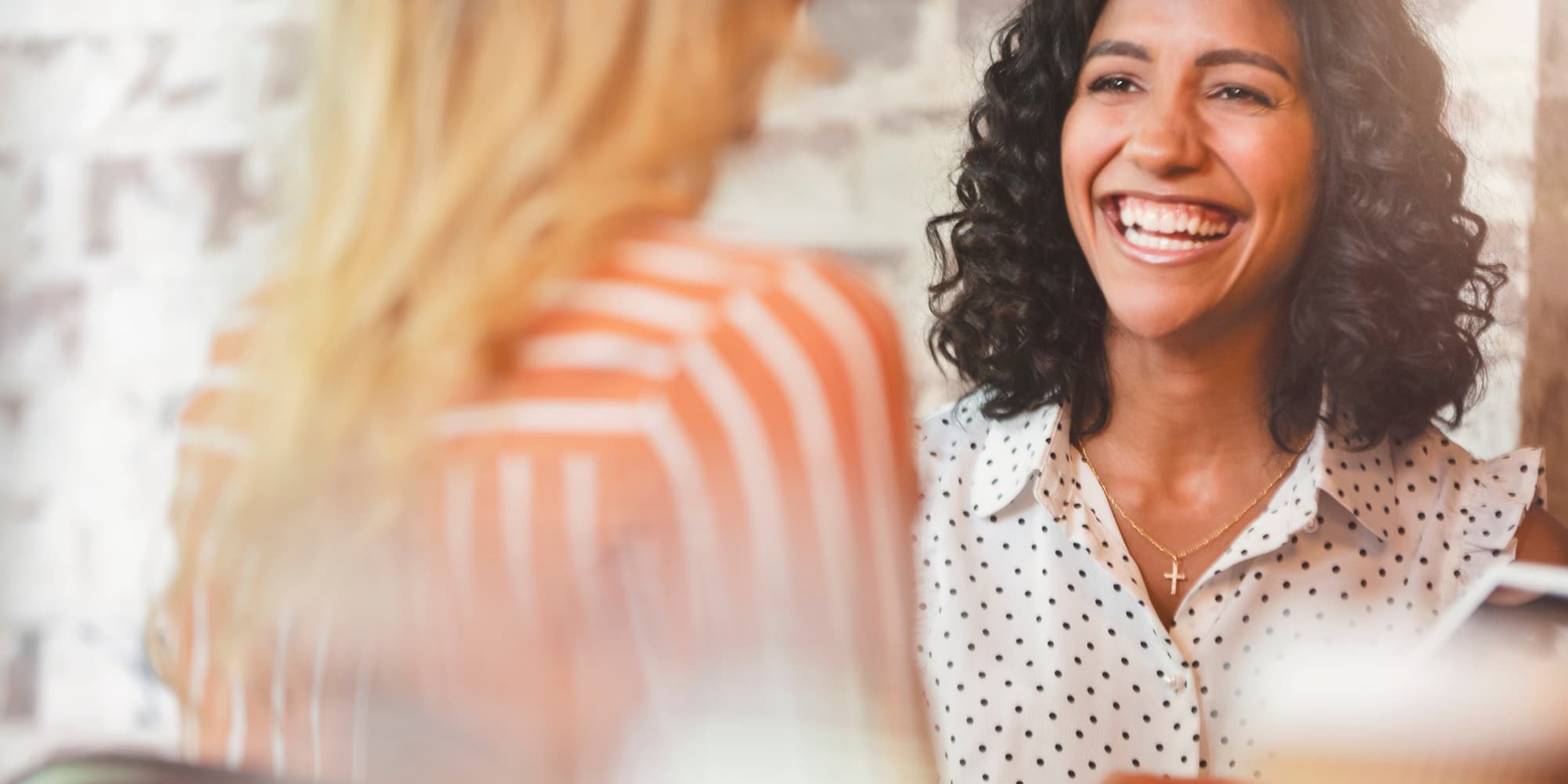two people talking at a job interview, one person smiling and facing the camera