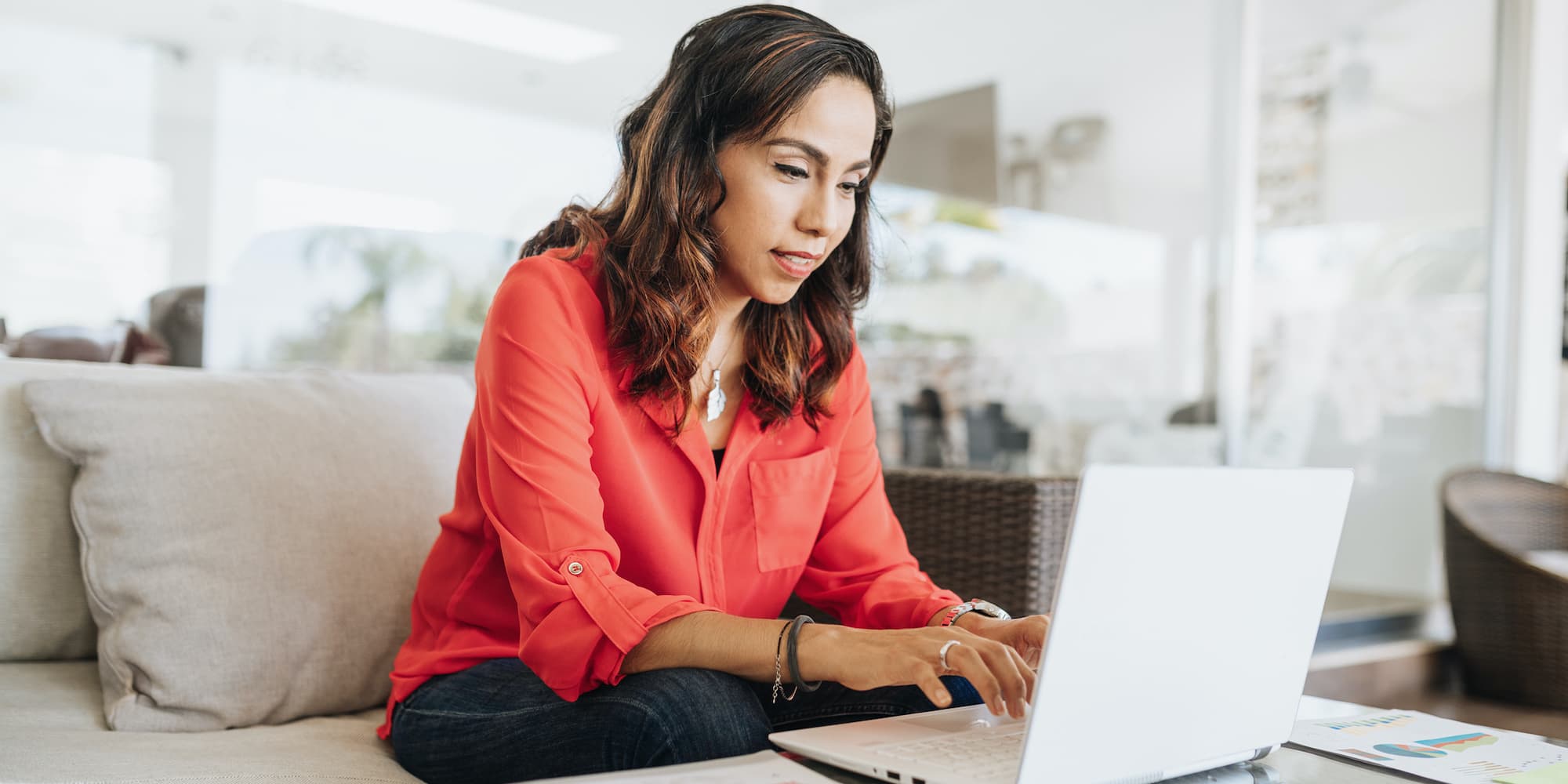 person on couch using laptop on coffee table