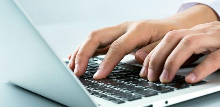 hands typing on laptop