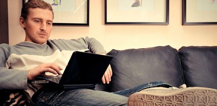 person sitting on the couch using a laptop