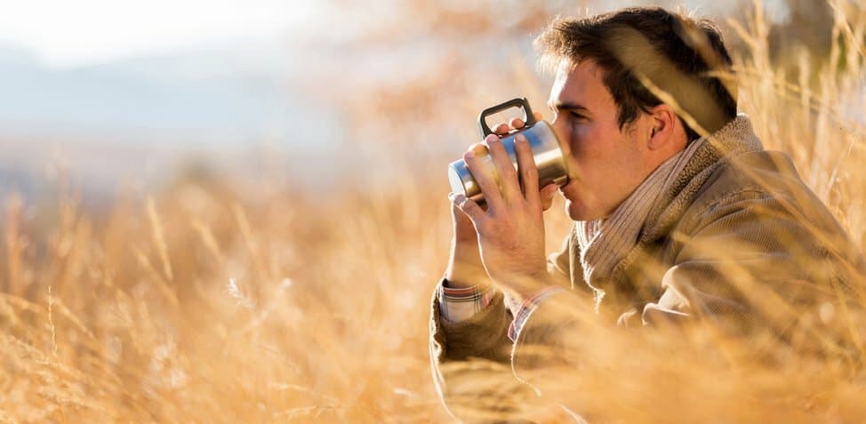 person drinking a warm beverage outside