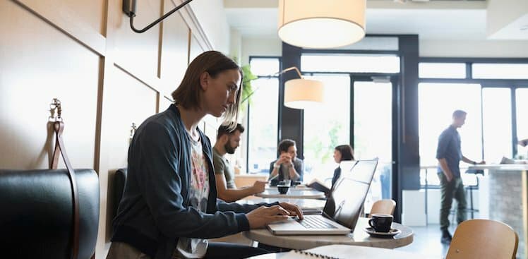person on laptop at cafe