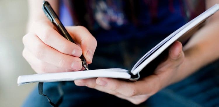 person writing in journal