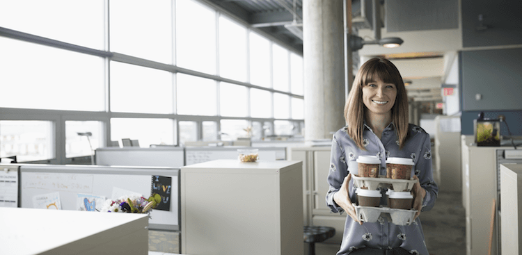 person carrying trays of coffee in an office