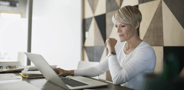 person sitting at office desk with laptop