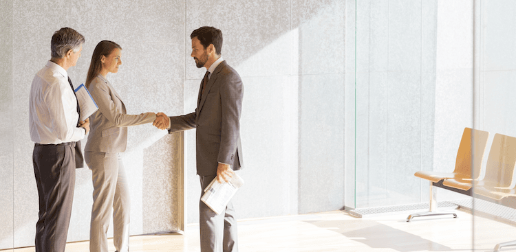 people shaking hands in the lobby of an office