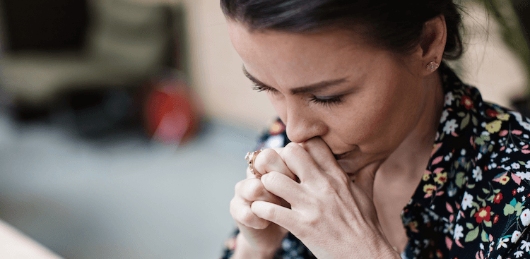 person with their head down on their hands