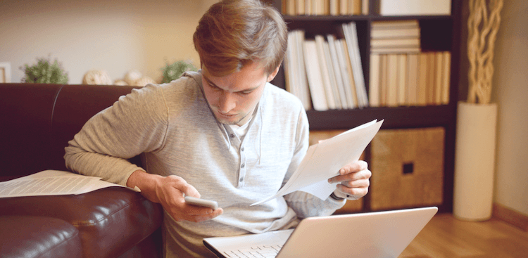 person looking at phone and laptop