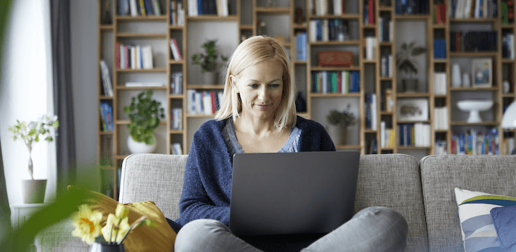 person sitting on a couch working on a laptop