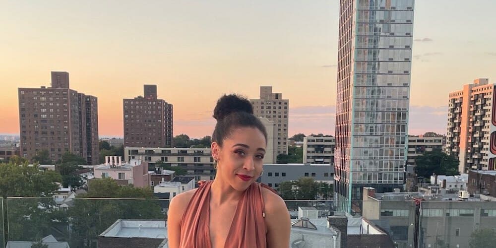 person with a bun standing in front of a city skyline