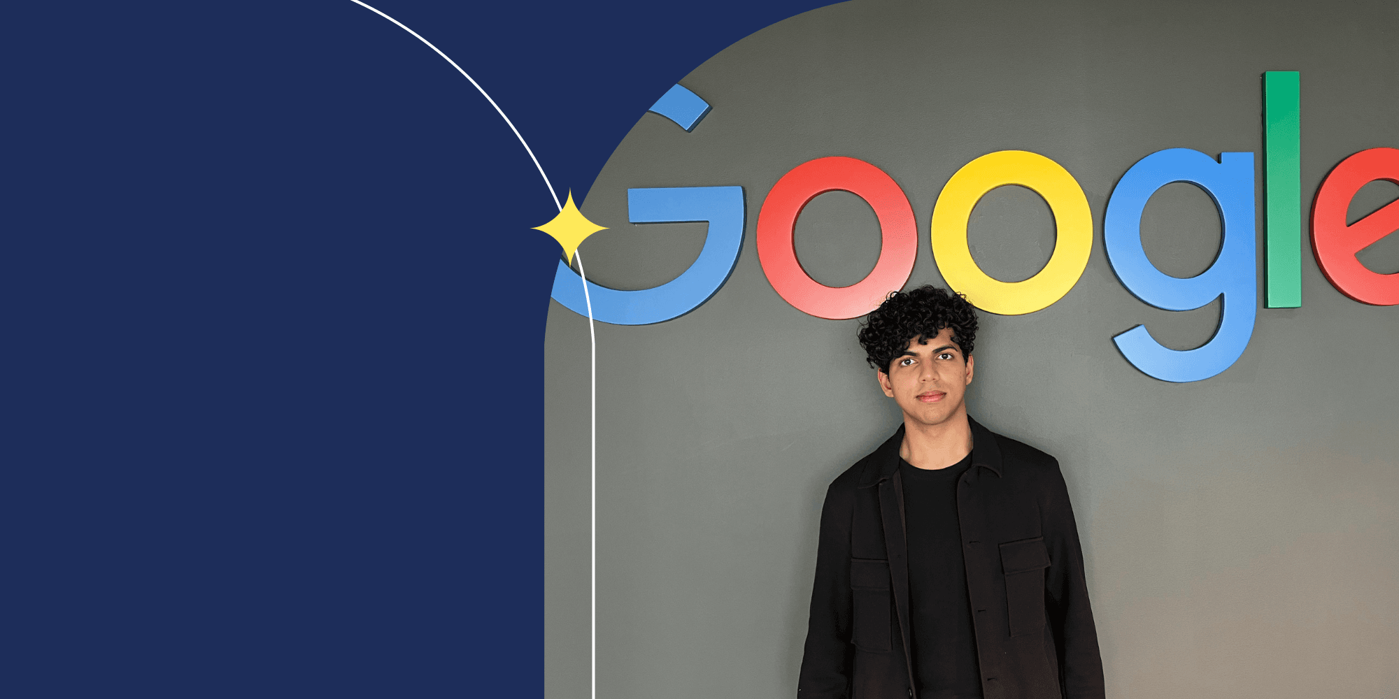 A person standing in front of a gray wall; the word "GOOGLE" is written above their head. The person wears a black jacket and black shirt.