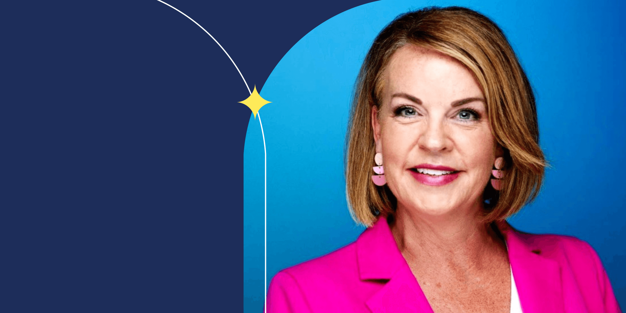 A person dressed in a pink blazer and facing the camera.