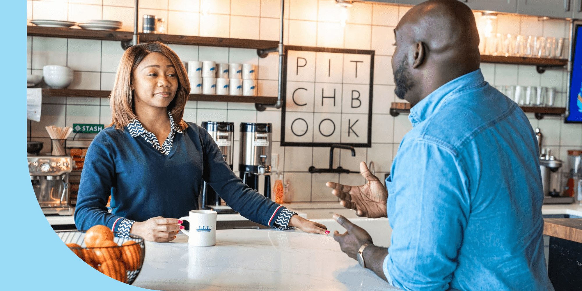 Two PitchBook employees in the company kitchen having a discussion over coffee