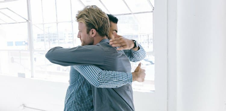 people hugging in office