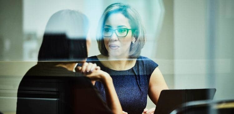 manager talking to employee in conference room