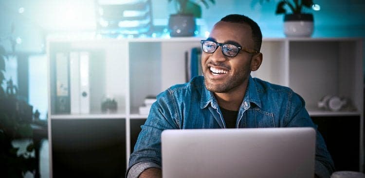 smiling person working on laptop